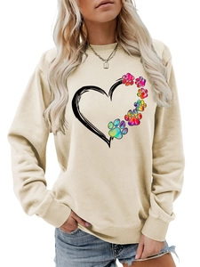 Detail of beige sweatshirt featuring a black heart and colorful paw print pattern