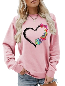 Close-up of pink sweatshirt featuring heart and colorful paw print graphic design