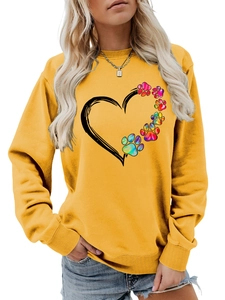 Detail of colorful rainbow paw print and heart graphic on yellow crewneck sweatshirt