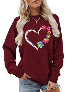 Close-up of heart and colorful paw print graphic on a wine red women's sweatshirt