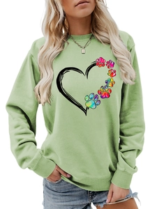 Close-up of sage green sweatshirt featuring colorful tie-dye paw print and heart design
