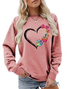 Detail of pink crewneck sweatshirt featuring artistic heart and colorful paw print design