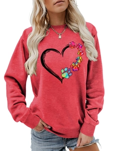 Detail of red crewneck sweatshirt featuring a colorful heart and paw print design