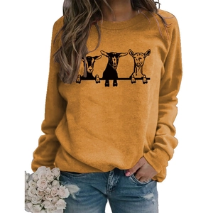 Détail d'un sweat à col rond jaune gingembre avec de mignons imprimés de chèvres