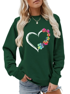 Close-up of heart and rainbow paw print design on dark green long sleeve sweatshirt