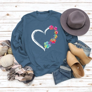 Teal blue sweatshirt with colorful heart and paw print on white wooden background