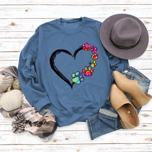 Flat lay of navy blue sweatshirt with colorful paw heart print and autumn accessories