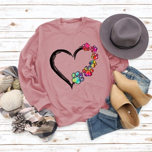 Flat lay of pink heart and rainbow paw print sweatshirt with autumn accessories