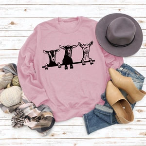 Sweat rose avec imprimé chèvre, accessoires d'automne sur fond en bois blanc rustique