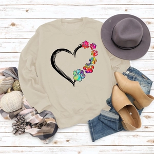 Close-up of heart and colorful dog paw print on beige long sleeve sweatshirt