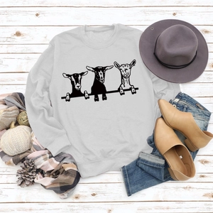 Mise à plat d'un sweat-shirt gris clair avec motif chèvre et accessoires d'automne
