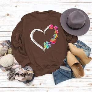 Flat lay of brown sweatshirt with heart and colorful paw print and autumn accessories