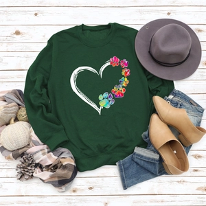 Detail of heart and rainbow paw print on dark green crewneck sweatshirt with autumn styling