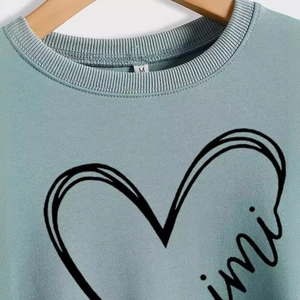Felpa verde chiaro girocollo con stampa a cuore e mini lettere su gruccia in legno