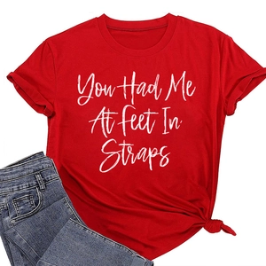 Dettaglio di una t-shirt rossa a girocollo con stampa grafica e jeans in denim