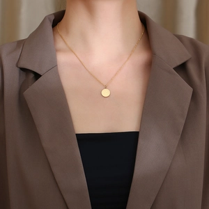 Dettaglio ravvicinato della collana con ciondolo cinese Fu dorato indossata da una modella