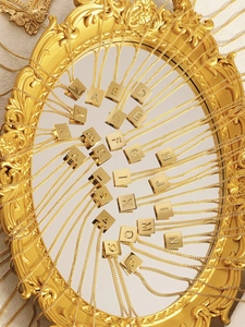 Makroaufnahme von 26 goldenen Buchstabenanhängern mit feinen Gliederketten