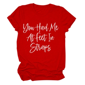 Dettaglio di t-shirt rossa con girocollo e stampa You Had Me At Feet In Straps bianca