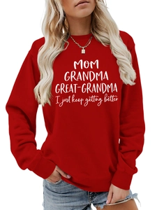 Détail d'un sweat-shirt rouge avec impression de lettres blanches 'MOM GRANDMA GREAT'