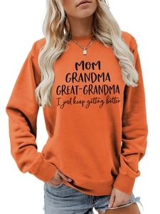 Détail du sweat orange avec imprimé MOM GRANDMA et poignets côtelés élastiques