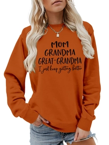 Détail du sweat orange avec lettrage MOM GRANDMA et poignets côtelés pour femmes