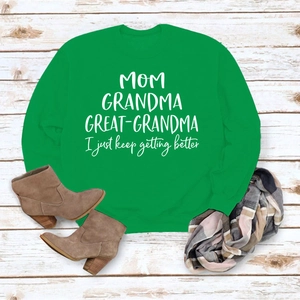 Mise à plat du sweat vert à manches longues avec lettrage familial blanc et bottines d'automne