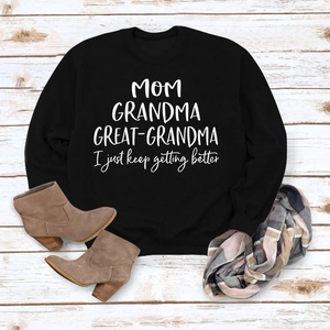 Détail d'un sweat noir avec lettrage blanc et accessoires d'automne sur bois