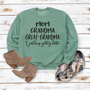 Mise à plat d'un t-shirt vert à manches longues avec texte MOM, bottines et écharpe
