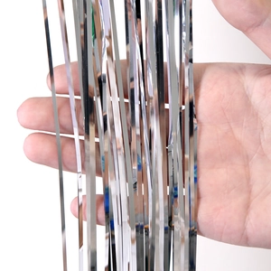 Close-up of shiny silver metallic tinsel fringe decoration for Christmas tree backdrop