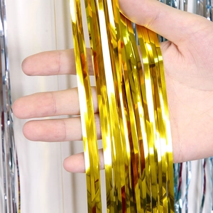 Macro detail of shiny gold tinsel streamers with metallic reflective finish for party decor