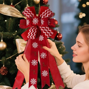 Detail of red fabric Christmas bow with snowflake and reindeer prints on a tree