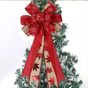Close-up of Christmas bow with red maple leaf and snowflake patterns on a tree