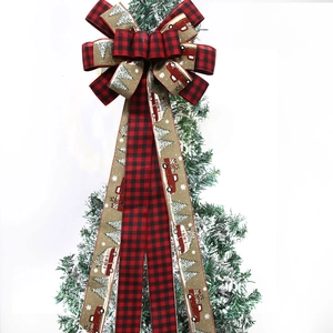 Detail of Christmas buffalo plaid bow with vintage red truck print on snowy tree branch