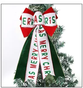 Detail of red and green velvet Christmas bow with Merry Christmas print on tree branch