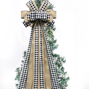 Buffalo plaid and burlap Christmas tree topper bow with long streamers on snowy tree