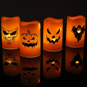 Set of four orange Halloween LED candles with pumpkin, ghost and skull patterns glowing