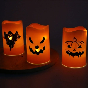 Detail of Halloween LED electronic candles with ghost and pumpkin patterns on wooden base