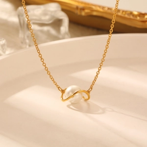 Vintage planet pearl necklace with golden metal ring on elegant white tray background