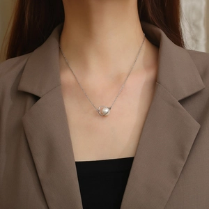 Detailed view of a vintage pearl pendant necklace on a silver chain for women