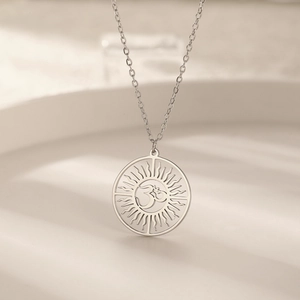 Vue détaillée du pendentif Om hindou argenté avec motif soleil évidé sur chaîne