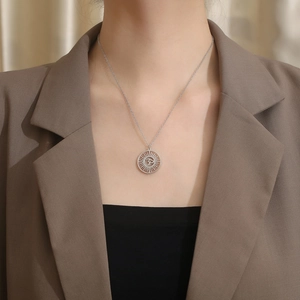 Collier avec pendentif Om hindou argenté et motif rayon de soleil porté par un mannequin