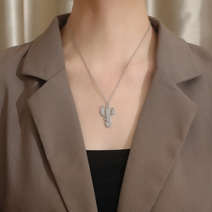 Gros plan d'un collier avec pendentif cactus en argent porté par un mannequin