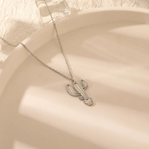 Collier pendentif cactus minimaliste en acier inoxydable pour femme sur plateau blanc