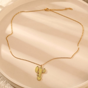 Détail du pendentif cactus doré avec lignes noires sur une chaîne à mailles fines