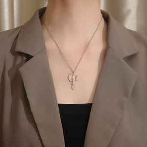Gros plan d'un collier pendentif cactus en or rose avec textures verticales sur mannequin