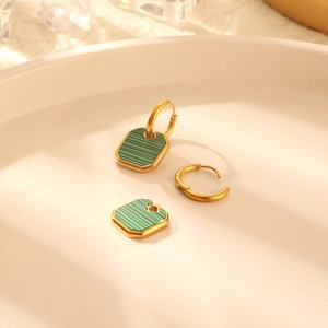 Golden titanium steel hoop earrings with green malachite octagon charms on white plate
