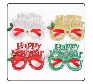Macro view of Happy New Year glasses in four glittery colors with festive snowflake details