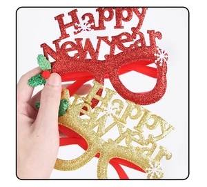 Detail of Happy New Year glitter glasses with snowflake patterns and holly accents