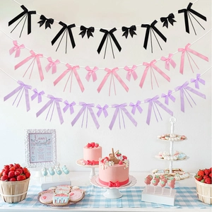 Dettaglio di ghirlande con fiocchi di nastro rosa e viola per decorazione festa a tema