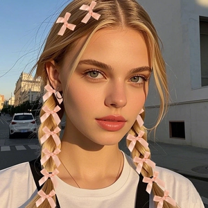 Accessori fiocco in seta rosa su una modella bionda in un ambiente urbano dal tono caldo